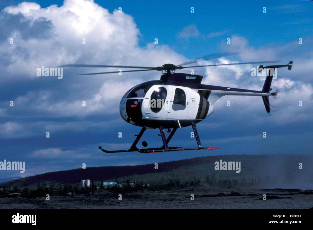 Un elicottero che si libra appena sopra il suolo, con le sue pale rotanti che girano. La scena cattura l'aereo in movimento, dimostrando la sua capacità di rimanere sospeso in aria. Foto Stock