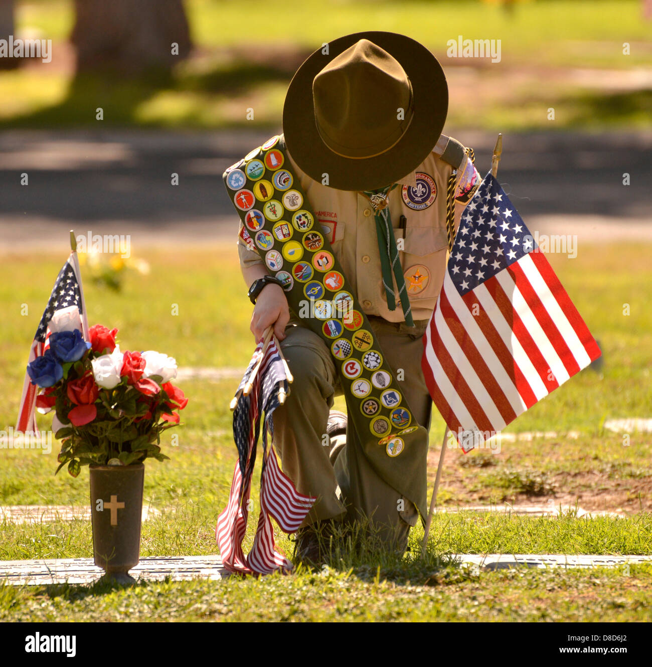 Prato Est Palms cimitero, Tucson, Arizona, Stati Uniti. Il 25 maggio 2013. Boy Scout, Ray Langlais, 13, di Catalina la truppa del consiglio 141 luoghi bandiere il 25 maggio 2013 presso le tombe dei defunti militari statunitensi reduci in preparazione per il lunedì è giorno memoriale servizi a Prato Est Palms cimitero, Tucson, Arizona, Stati Uniti. Langlais dice che egli aiuta a collocare le bandiere per "aiutare il mio paese". Suo padre Ray Langlais Suor aggiunto che mettendo le bandiere presso le tombe 'rementi di persone di che cosa il Memorial Day è supposto per essere . Si tratta di un ricordo di persone che hanno servito il nostro paese.' Credit: Norma Jean Gargasz/Alamy Live News Foto Stock