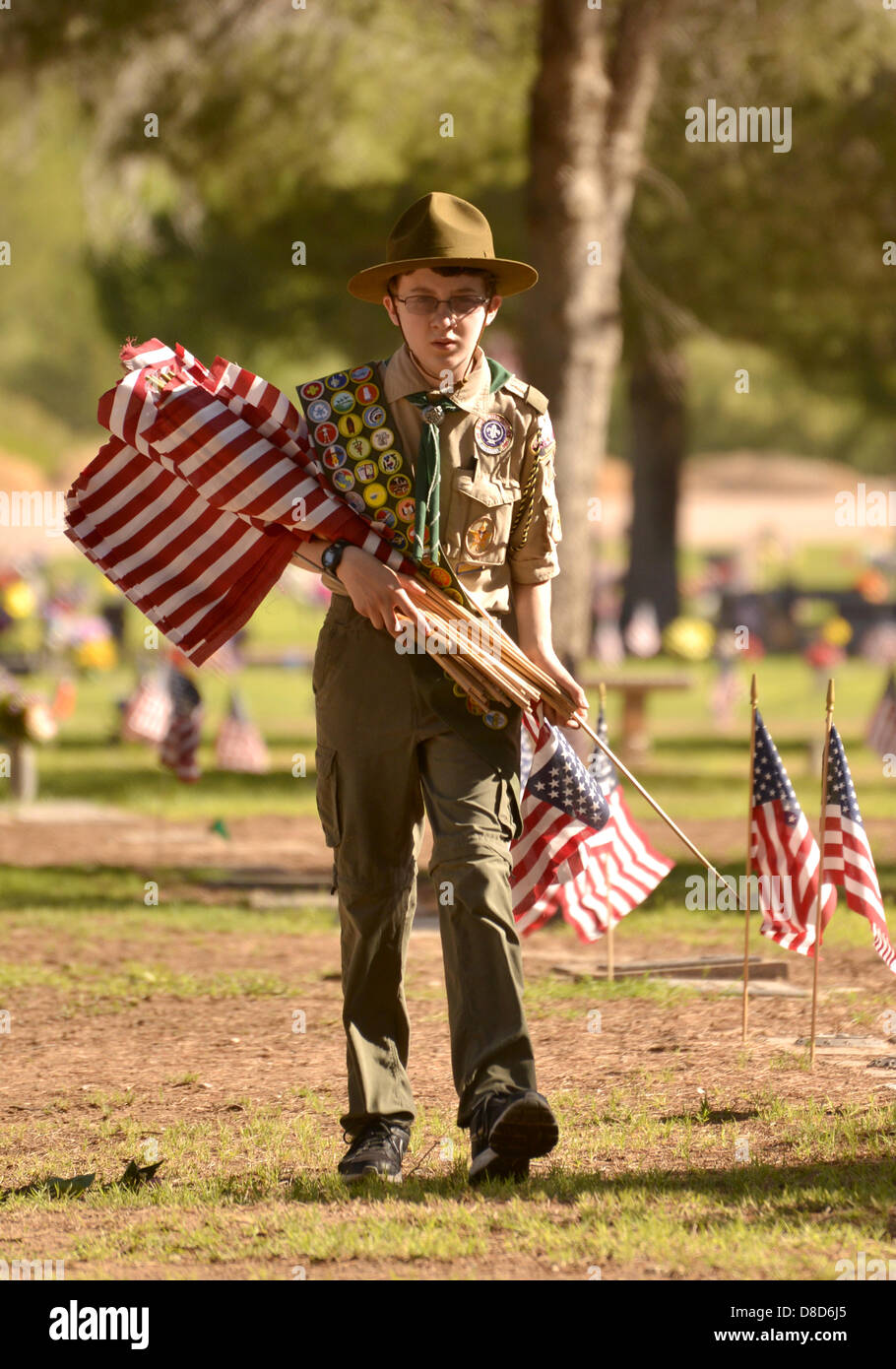 Prato Est Palms cimitero, Tucson, Arizona, Stati Uniti. Il 25 maggio 2013. Boy Scout, Ray Langlais, 13, di Catalina la truppa del consiglio 141 luoghi bandiere il 25 maggio 2013 presso le tombe dei defunti militari statunitensi reduci in preparazione per il lunedì è giorno memoriale servizi a Prato Est Palms cimitero, Tucson, Arizona, Stati Uniti. Langlais dice che egli aiuta a collocare le bandiere per "aiutare il mio paese". Suo padre Ray Langlais Suor aggiunto che mettendo le bandiere presso le tombe 'rementi di persone di che cosa il Memorial Day è supposto per essere . Si tratta di un ricordo di persone che hanno servito il nostro paese.' Credit: Norma Jean Gargasz/Alamy Live News Foto Stock