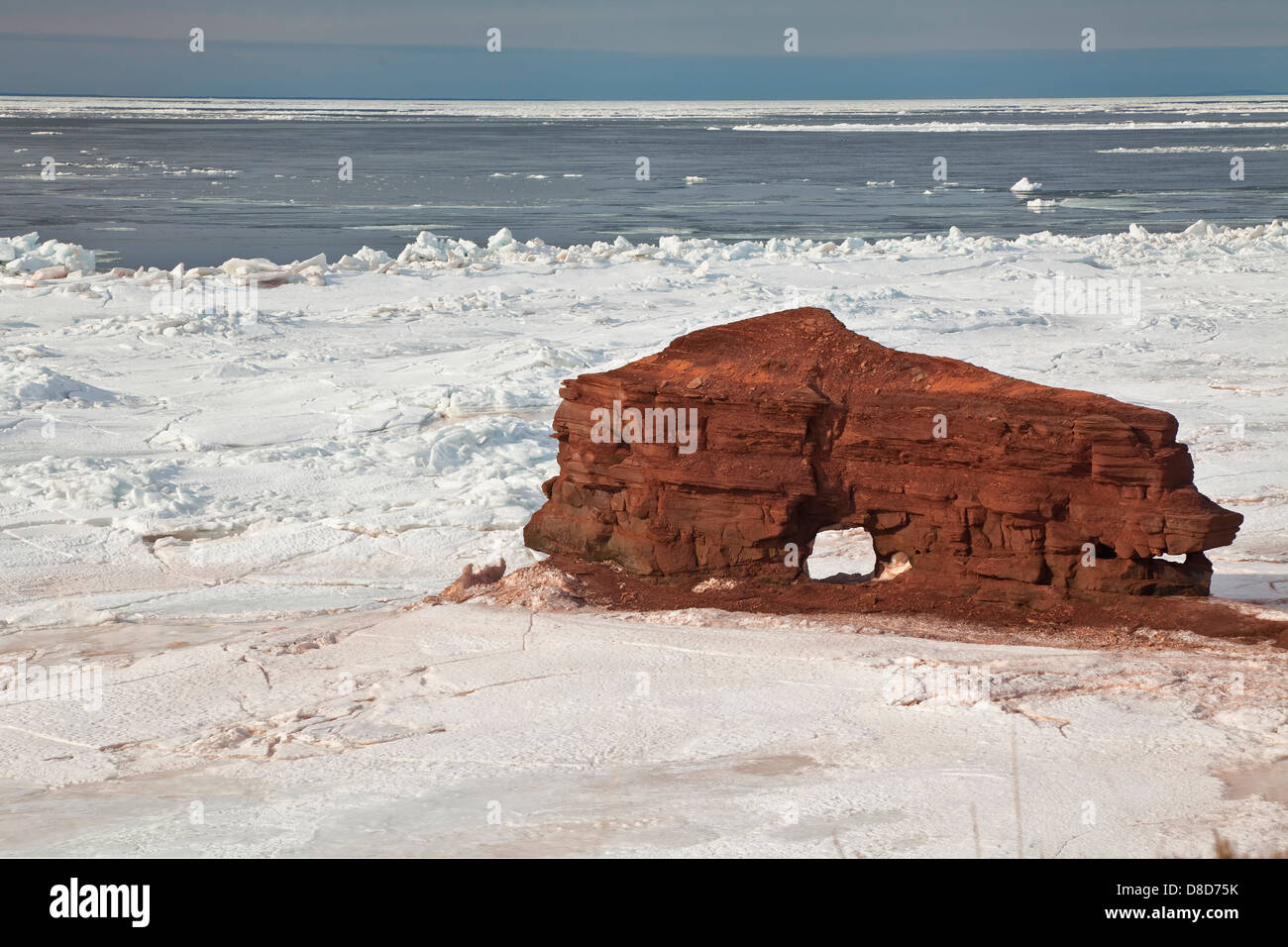 Rompere il ghiaccio attorno ad un interessante prodotto di erosione, una roccia arenaria formazione lungo la costa di Prince Edward Island,Canada Foto Stock