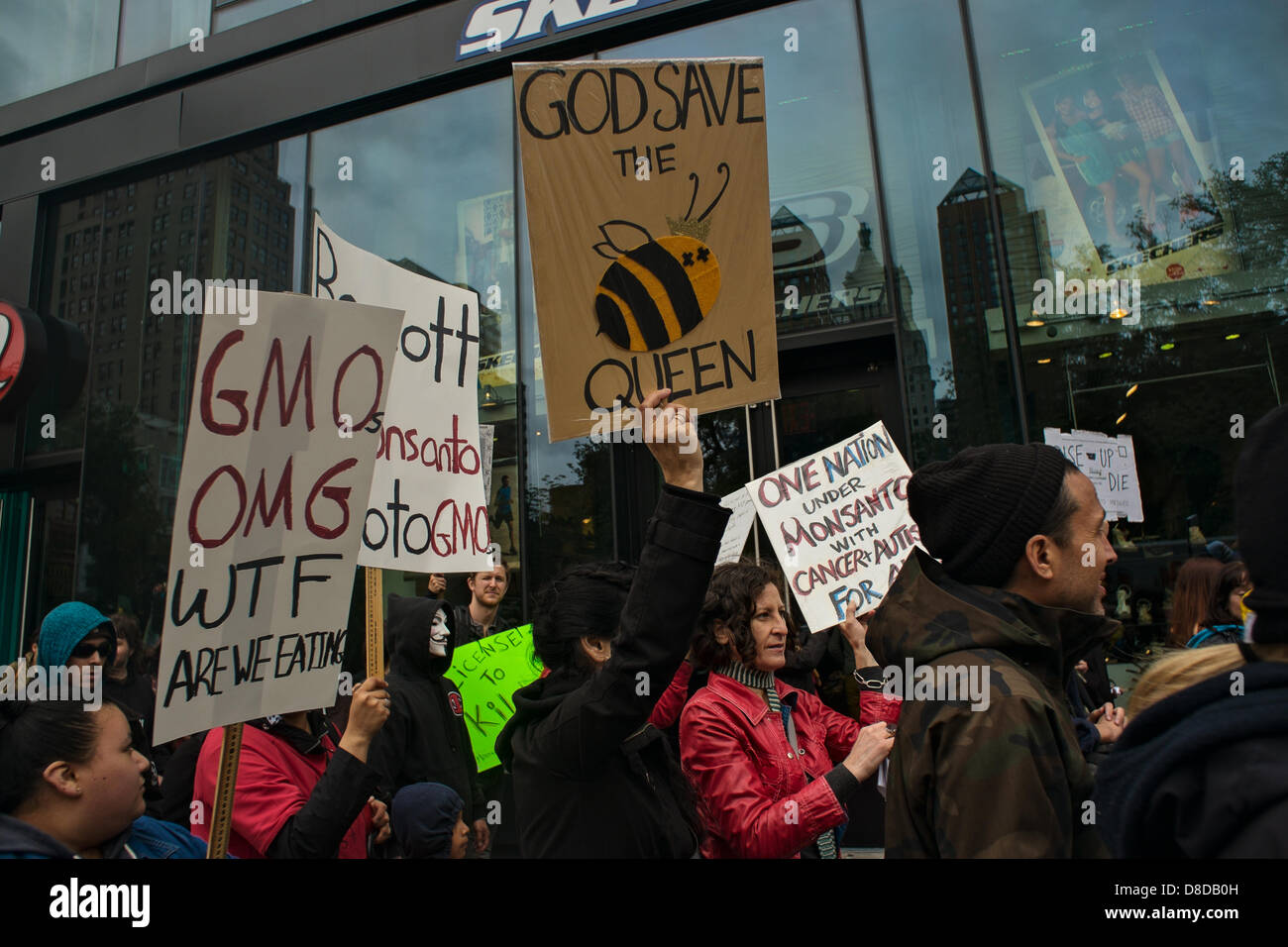 New York, NY, 25 maggio 2013. Persone azienda segni, compresa una lettura "Dio salvi la regina' portanti di una immagine di un ape, durante il mese di marzo di New York Union Square contro gli Stati Uniti-basato agricoltura e biotecnologie corporation Monsanto. Il rally e successiva marzo è stato uno dei molti attraverso gli Stati Uniti e di decine di altri paesi. Gli organizzatori sperano di diffondere la parola su ciò che dicono sono gli effetti nocivi di alimenti geneticamente modificati. Foto Stock