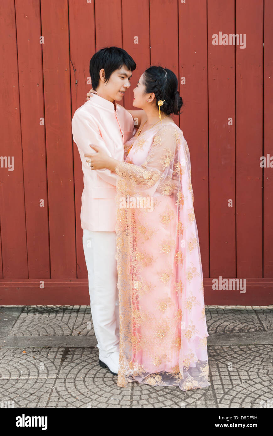 Asian Thai groom sta cercando la sua sposa in volto sorridente. Foto Stock