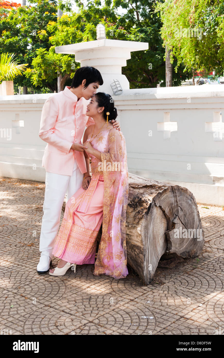 Asian Thai groom sta baciando la sua sposa di fronte nel volto sorridente. Foto Stock