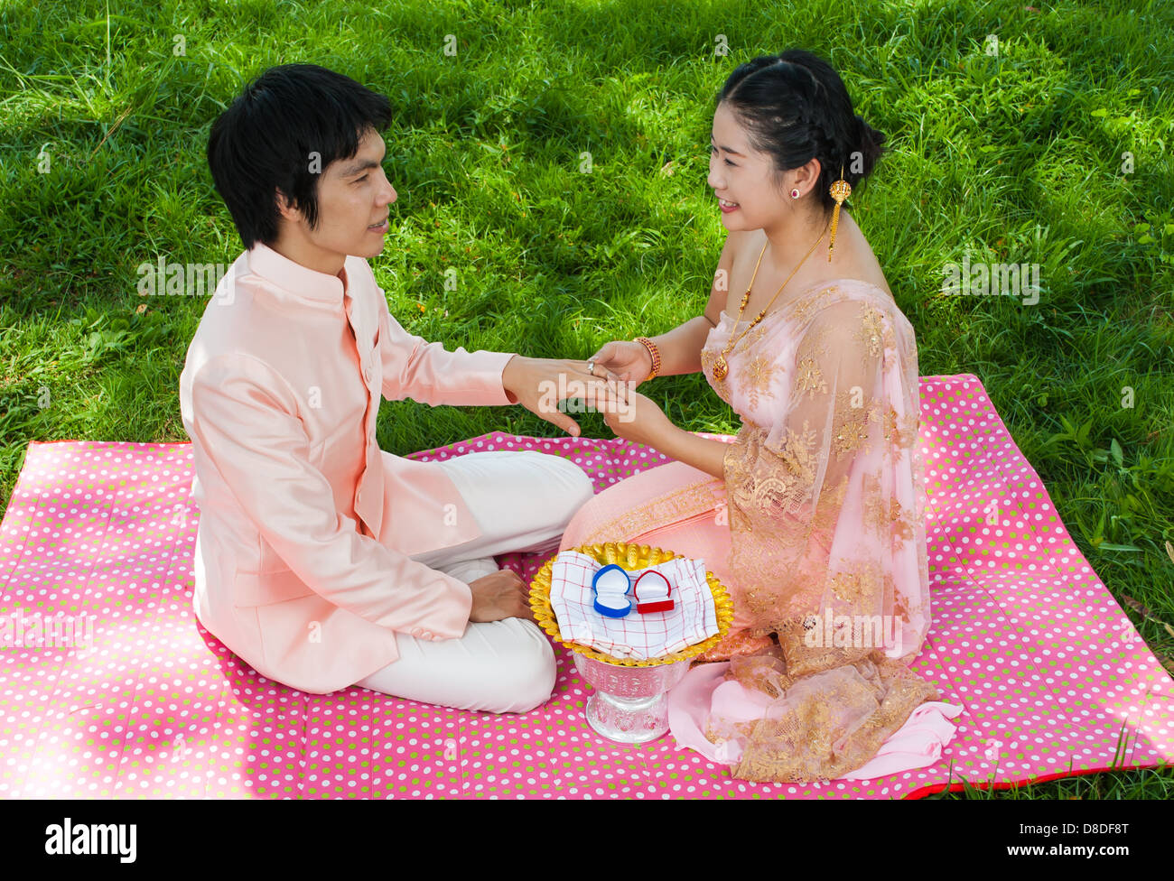 Asian Thai sposa indossa l'anello nuziale al suo Sposo nella cerimonia Thailandese con sensazione di felicità. Foto Stock
