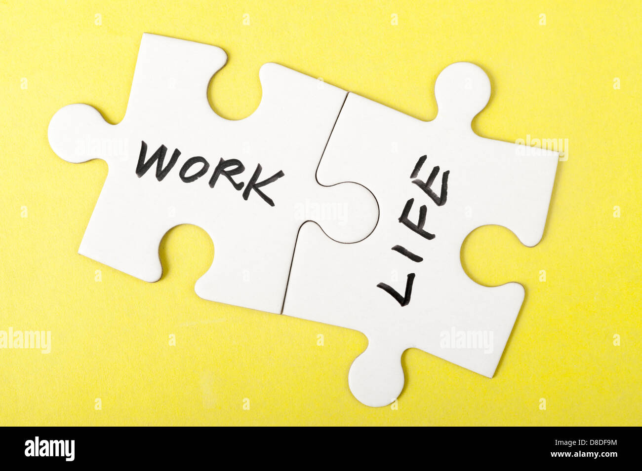 Il lavoro e la vita parole scritte su due pezzi del puzzle Foto Stock
