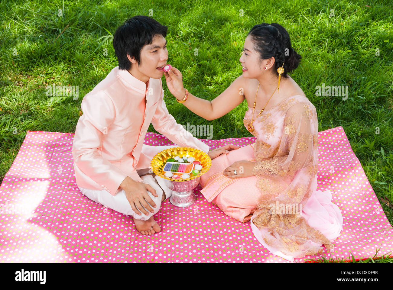 Asian Thai sposa è colorato di alimentazione Thai dessert al suo sposo con amore sensazione. Foto Stock
