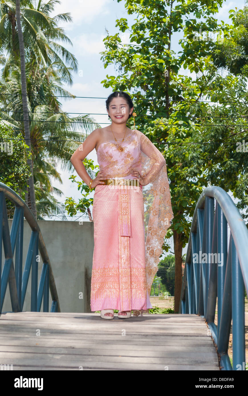 Asian Thai woman/Sposa in matrimonio Tailandese tuta è in piedi al centro del ponte blu. Foto Stock