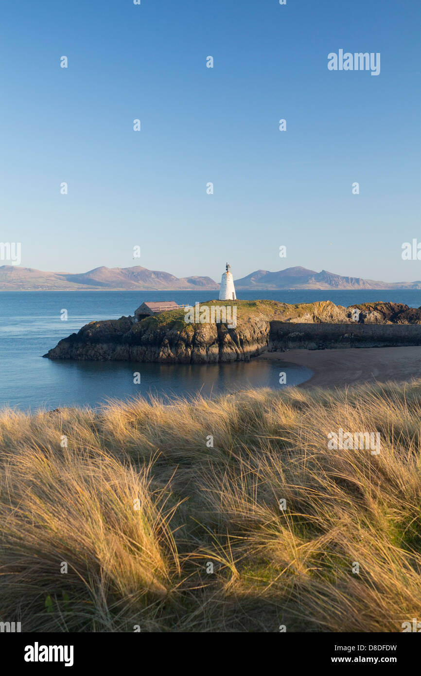 Llanddwyn Island Lighthouse e sulla spiaggia al tramonto, guardando sopra Caernarfon Bay verso la penisola di Llyn Anglesey North Wales UK Foto Stock