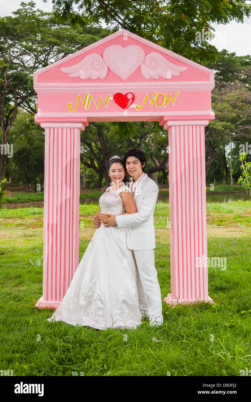 Asian Thai in nuziale abito nuziale è in piedi di fronte all amore del cancello come il principe e la principessa. Foto Stock