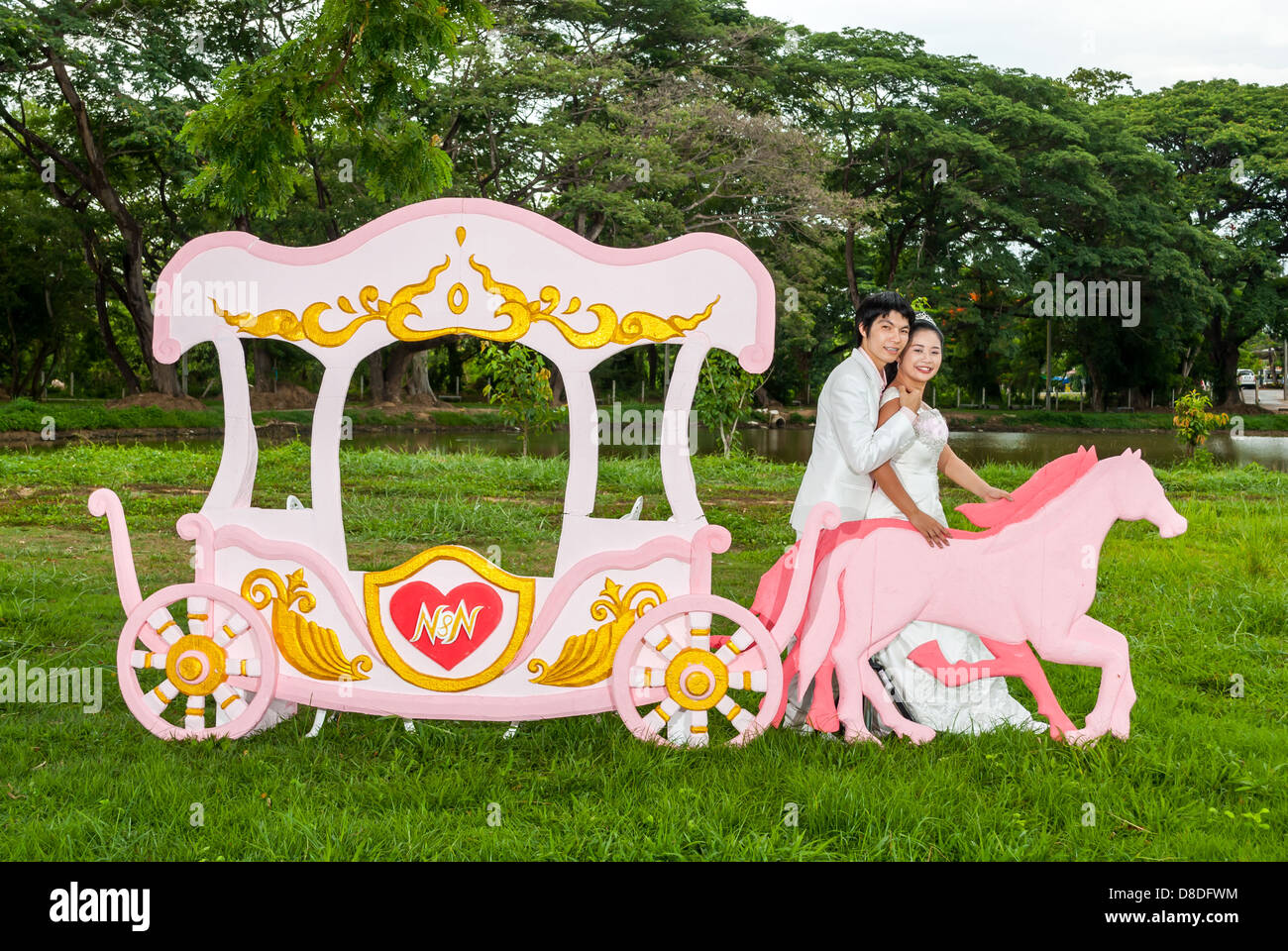 Asian nuziale tailandese è in piedi con il cavallo accanto al carrello romantico con tema d'amore come il principe e la principessa. Foto Stock