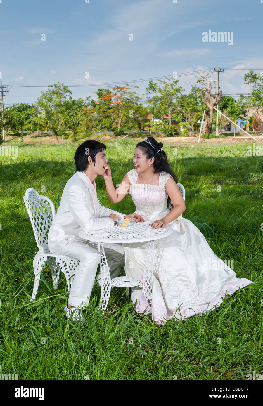 Asian Thai nuziale di alimentazione è il pezzo di torta di nozze al suo sposo in questo momento come il principe e la principessa. Foto Stock