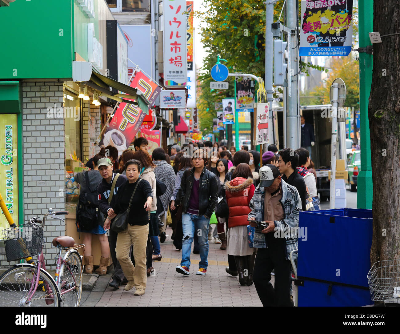 Persone non identificate a piedi attraverso un piccolo viale con negozi e ristoranti nella famosa zona di Shinjuku di Tokyo, Giappone Foto Stock