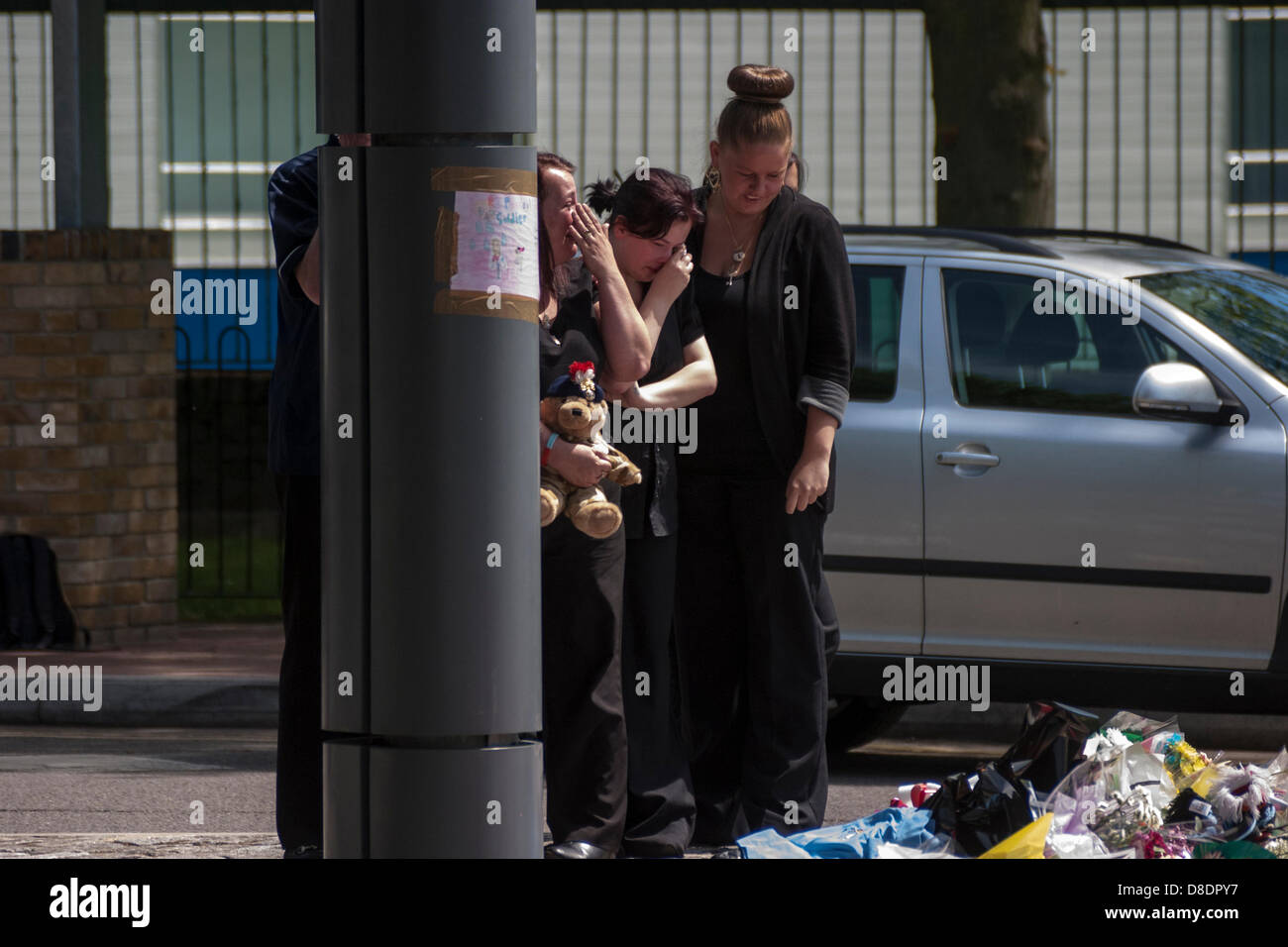 Londra, Regno Unito. 26 Maggio, 2013. Piangendo membri del batterista Lee Rigby guardare le molte migliaia di omaggi floreali sinistro esterno della Royal Artillery Woolwich della caserma dove assassinato soldato, il batterista Lee Rigby ha lavorato e vissuto. Credito: Paolo Davey/Alamy Live News Foto Stock