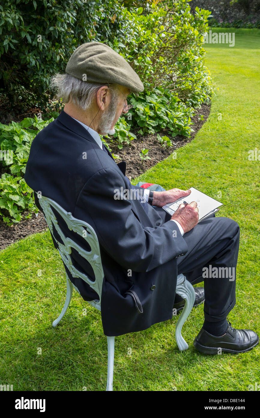 Uomo anziano il disegno di una foto in un giardino. Foto Stock