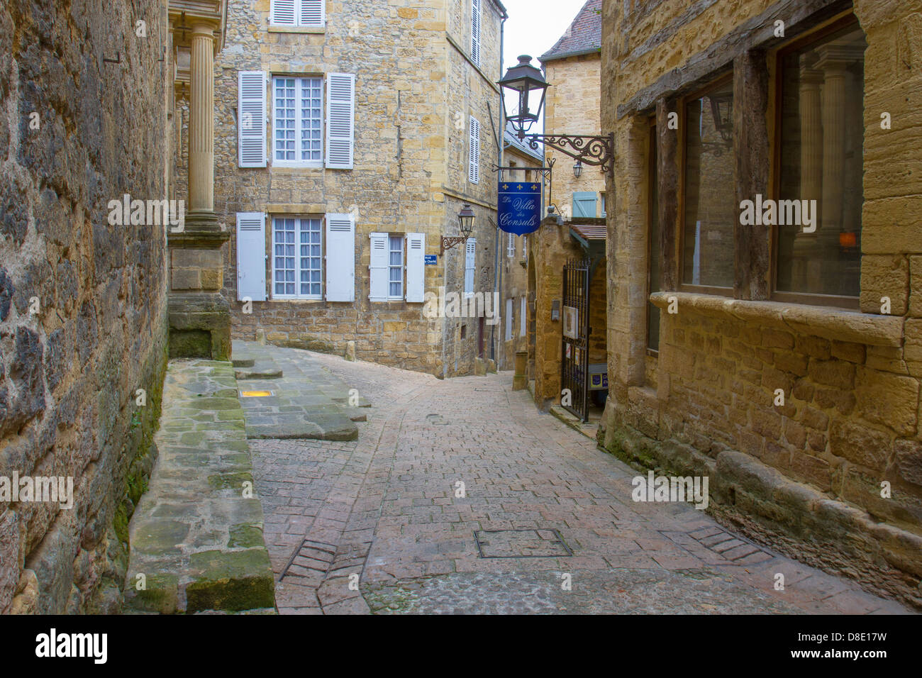 In ciottoli di strette strade medievali tra i palazzi in pietra arenaria rivestita con alberghi in un affascinante Sarlat Dordogne regione della Francia Foto Stock