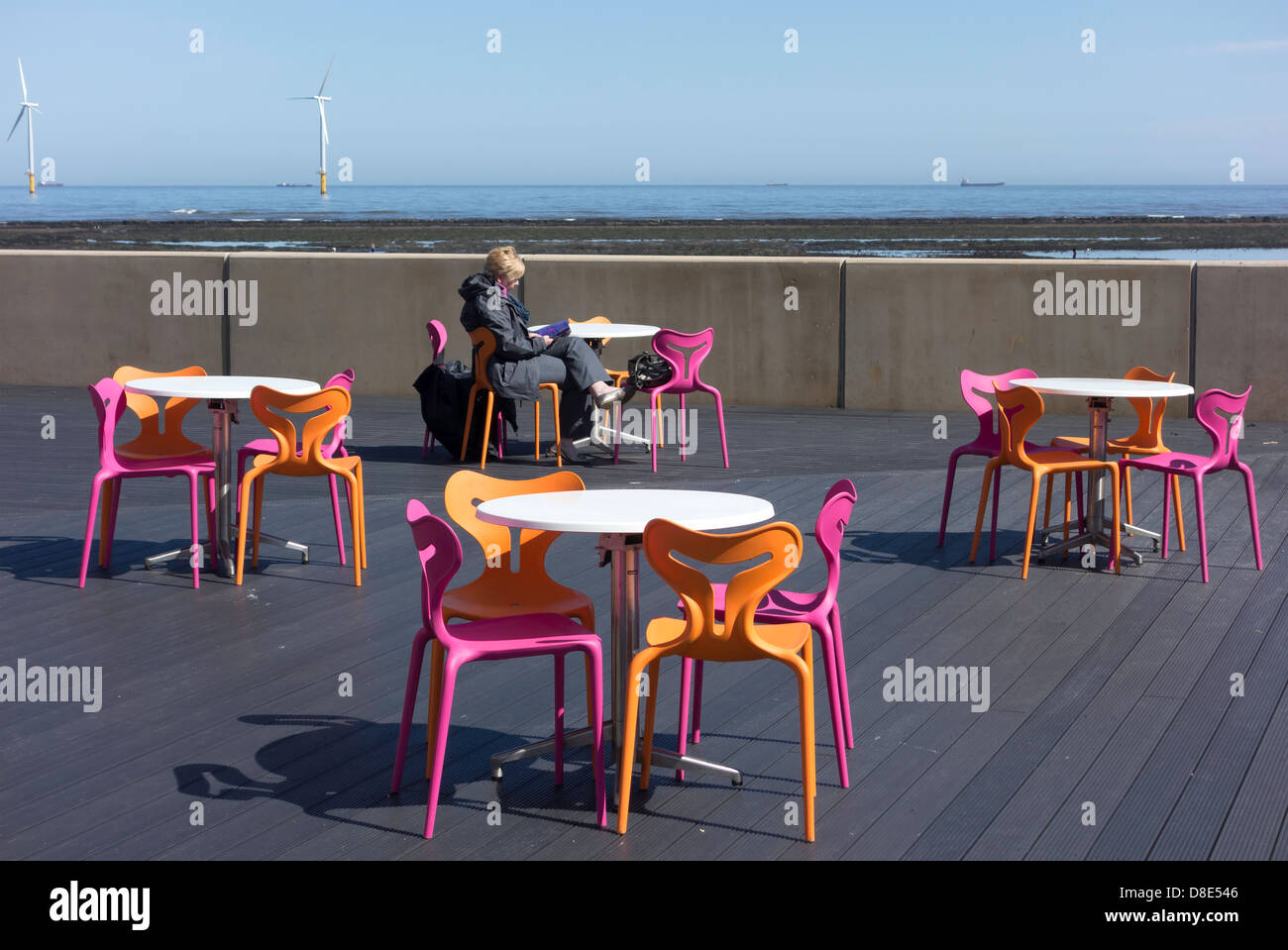 Una donna godendo il sole primaverile sulla terrazza sulla terrazza all Seasons Café presso il Redcar Beacon Foto Stock