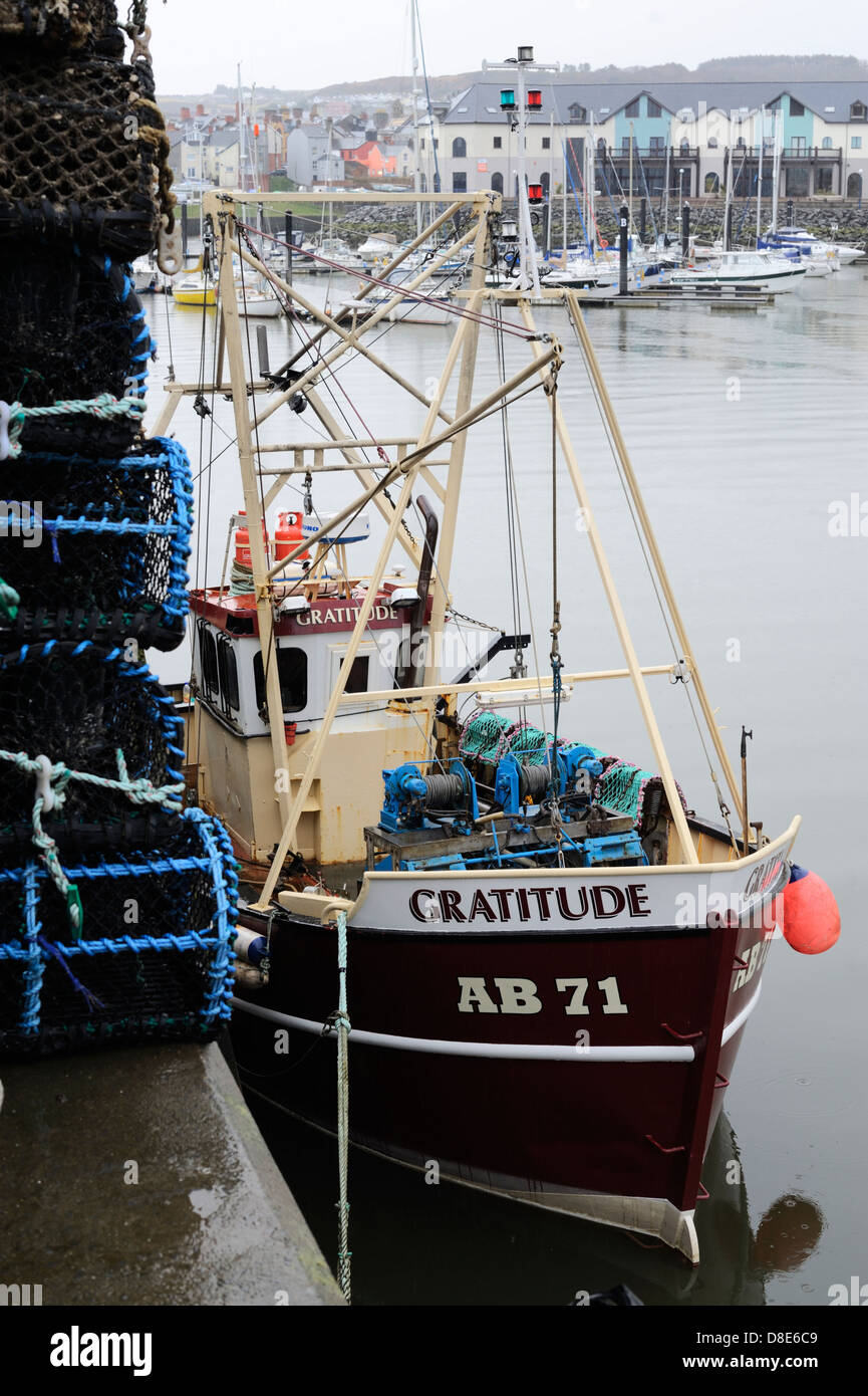 Barca da pesca in banchina con la pila di aragosta pentole o nasse, Aberystwyth, Wales, Regno Unito. Foto Stock