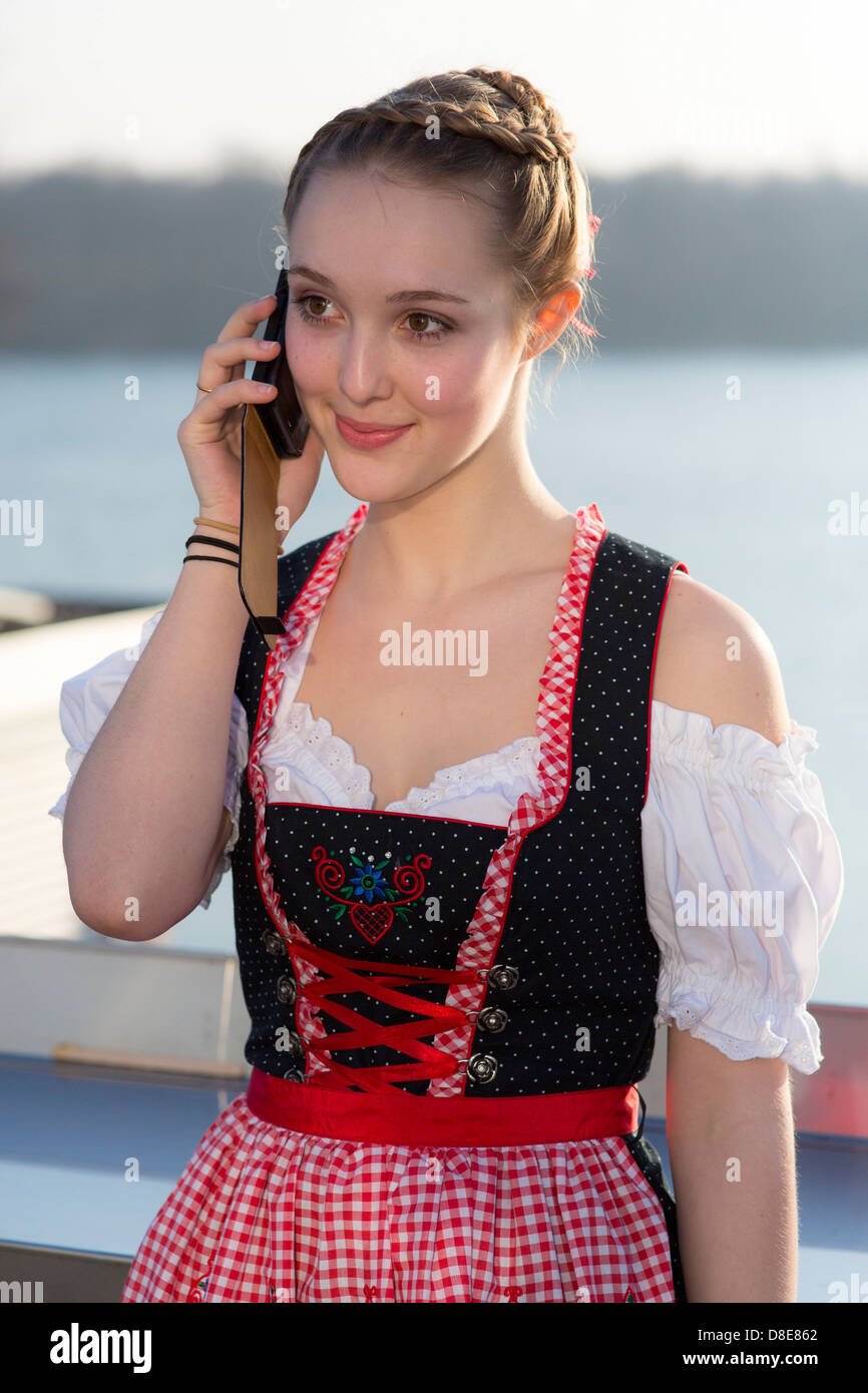 Ragazza adolescente indossando dirndl con telefono cellulare, Lichtenau, Baden-Wuerttemberg, Germania, Europa Foto Stock