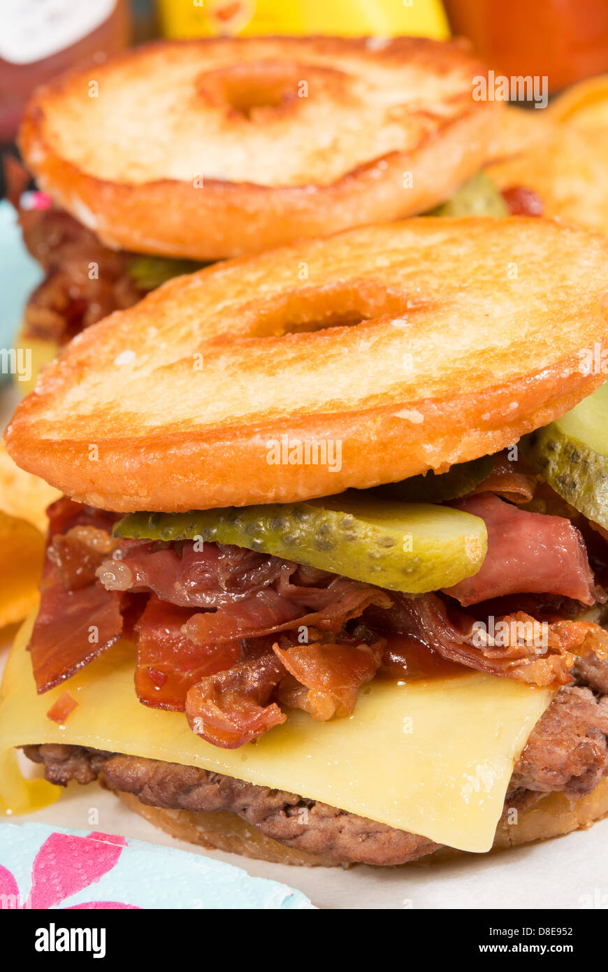 Il Luther burger: una polpetta di carne, formaggio, pancetta croccante e cetriolini tra due metà di un anello di vetrata a ciambella. Foto Stock