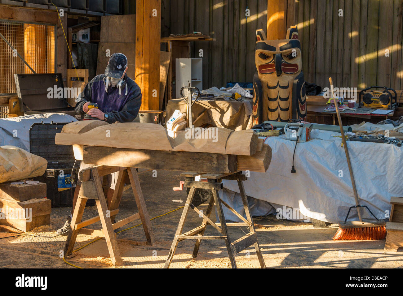 Carver in totem carving shed, Granville Island, Vancouver, British Columbia, Canada Foto Stock