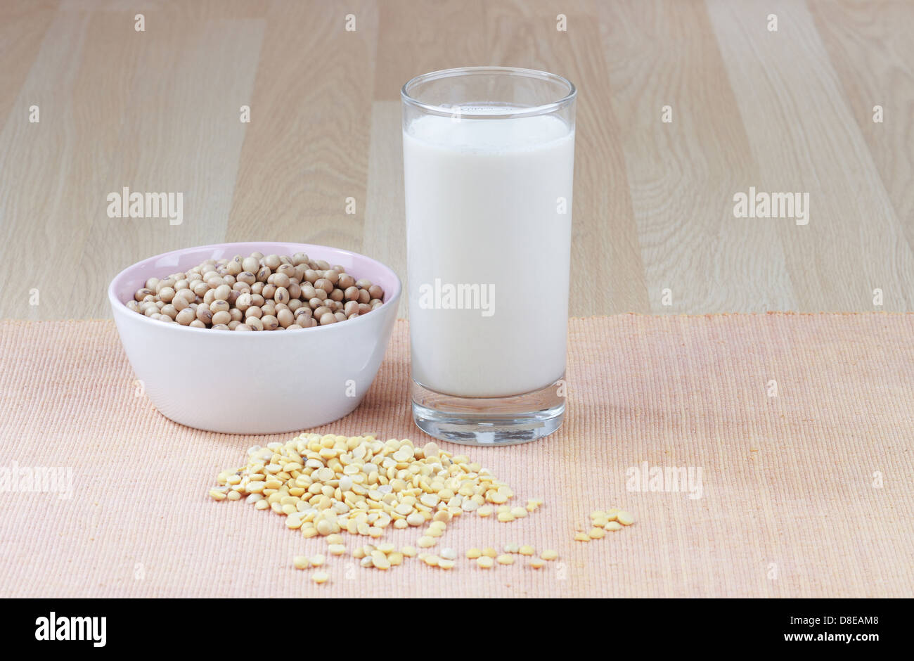 Un bicchiere di latte di soia con una ciotola di materie di semi di soia e semi di soia Foto Stock