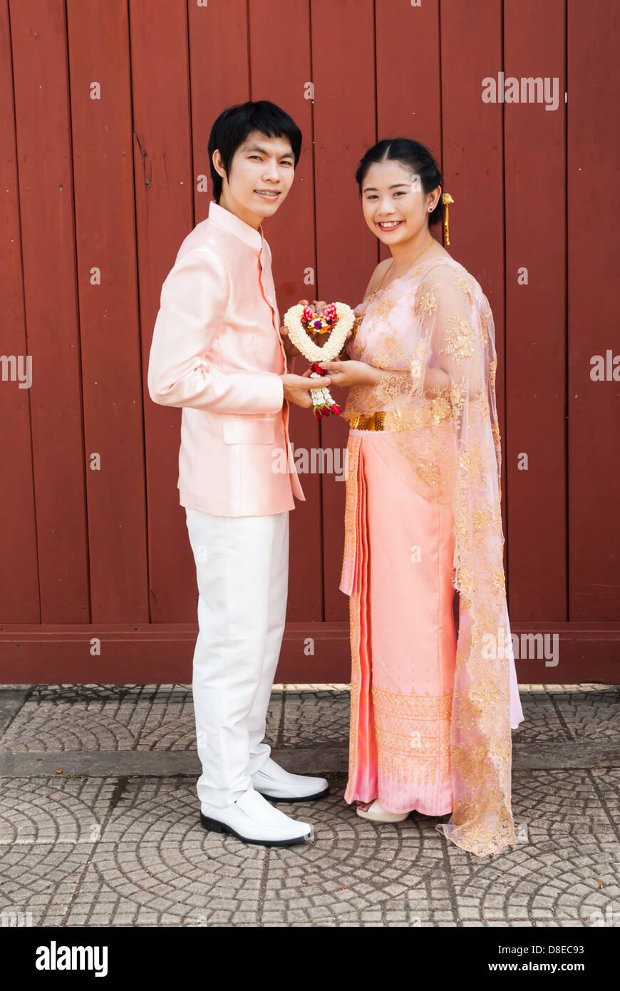 Asian Thai in Nuziale matrimonio Tailandese tuta con forma di cuore ghirlanda fiorita Foto Stock