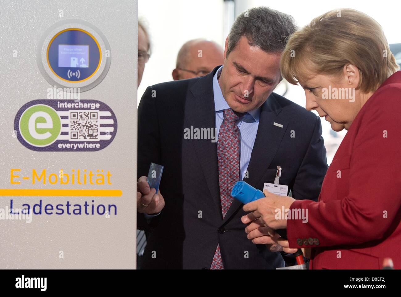 CEO di EnBW AG, Frank Mastiaux spiega il Cancelliere tedesco Angela Merkel (CDU) di una stazione di carica della sua azienda durante la Conferenza Internazionale su Electromobility a Berlino, Germania, 27 maggio 2013. I rappresentanti dell' industria, sciende e politica si incontrano per due giorni su invito del governo tedesco sotto il motto "Electromobility si muove in tutto il mondo". Foto: SOEREN STACHE Foto Stock