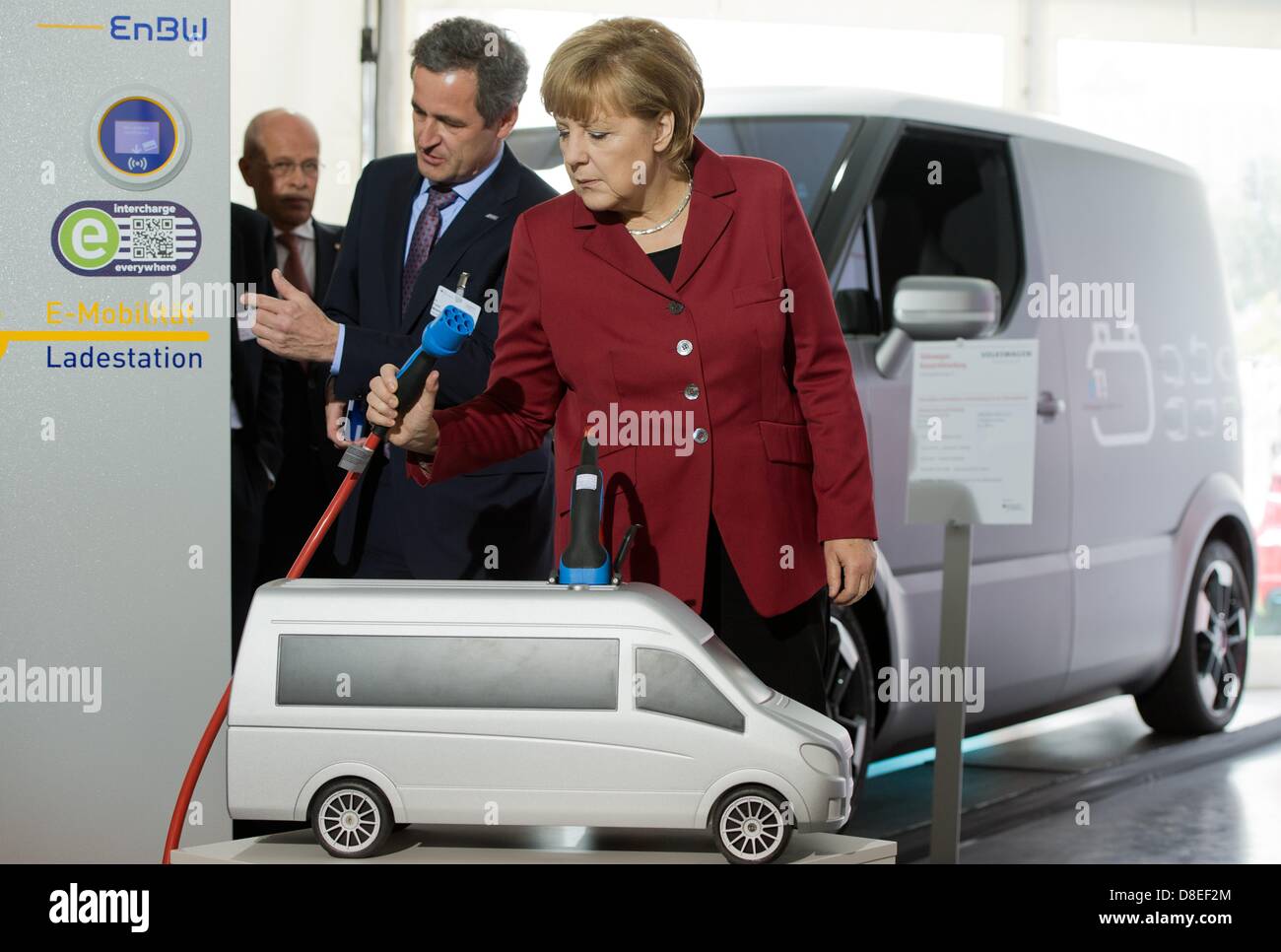 CEO di EnBW AG, Frank Mastiaux (C) eyplains il Cancelliere tedesco Angela Merkel (CDU) di una stazione di carica della sua azienda durante la Conferenza Internazionale su Electromobility a Berlino, Germania, 27 maggio 2013. I rappresentanti dell' industria, sciende e politica si incontrano per due giorni su invito del governo tedesco sotto il motto "Electromobility si muove in tutto il mondo". Foto: SOEREN STACHE Foto Stock