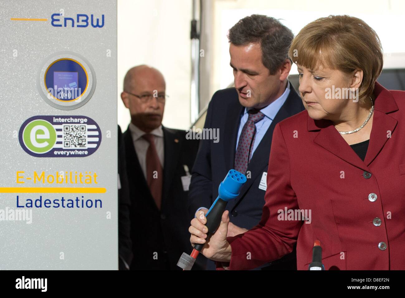 CEO di EnBW AG, Frank Mastiaux (C) eyplains il Cancelliere tedesco Angela Merkel (CDU) di una stazione di carica della sua azienda durante la Conferenza Internazionale su Electromobility a Berlino, Germania, 27 maggio 2013. I rappresentanti dell' industria, sciende e politica si incontrano per due giorni su invito del governo tedesco sotto il motto "Electromobility si muove in tutto il mondo". Foto: SOEREN STACHE Foto Stock