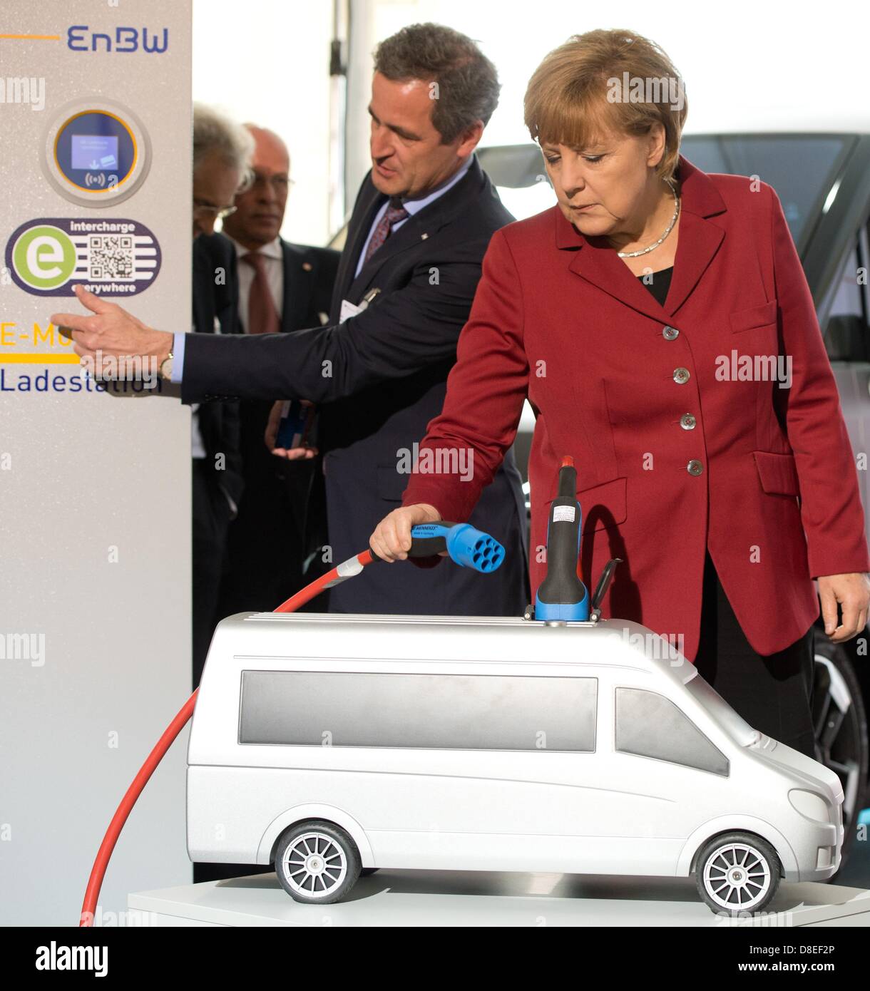 CEO di EnBW AG, Frank Mastiaux spiega il Cancelliere tedesco Angela Merkel (CDU) di una stazione di carica della sua azienda durante la Conferenza Internazionale su Electromobility a Berlino, Germania, 27 maggio 2013. I rappresentanti dell' industria, sciende e politica si incontrano per due giorni su invito del governo tedesco sotto il motto "Electromobility si muove in tutto il mondo". Foto: SOEREN STACHE Foto Stock