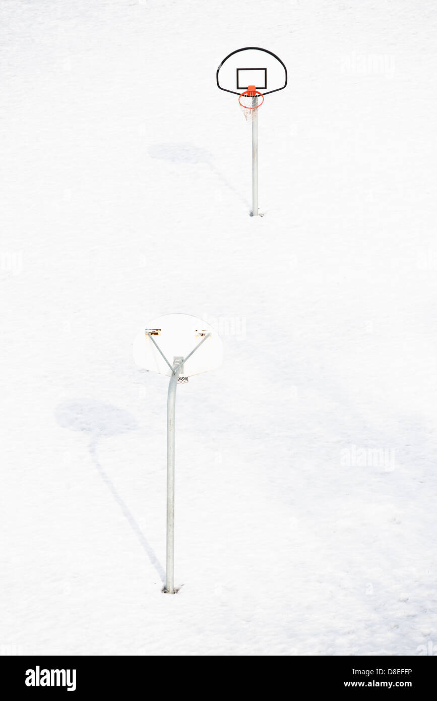 Svuotare outdoor pallacanestro in inverno con il campo coperto di neve e ghiaccio Foto Stock