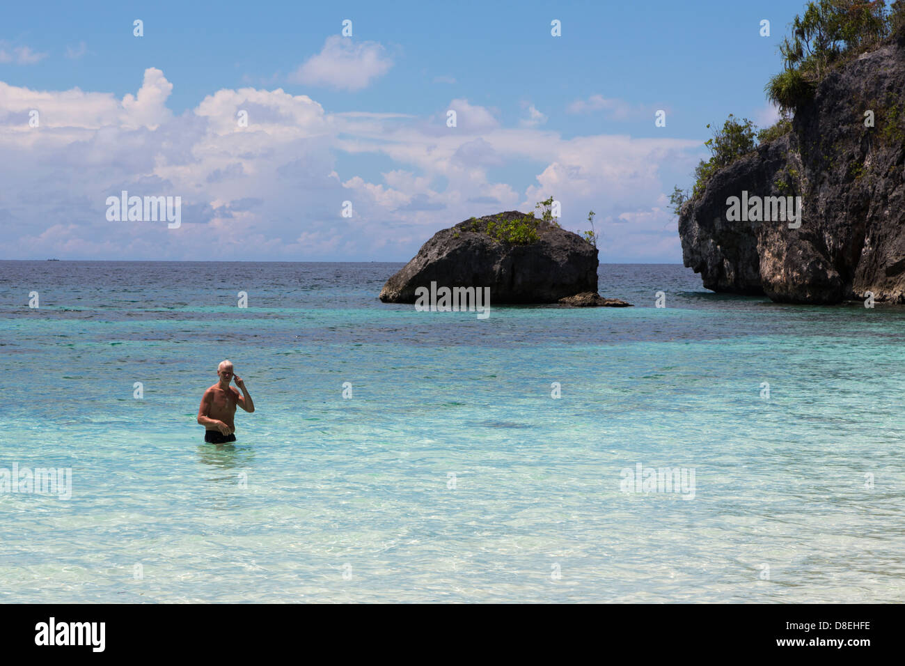 Uomo caucasico godendo immacolate acque nel remoto arcipelago Togian nell isola di Sulawesi, Indonesia Foto Stock