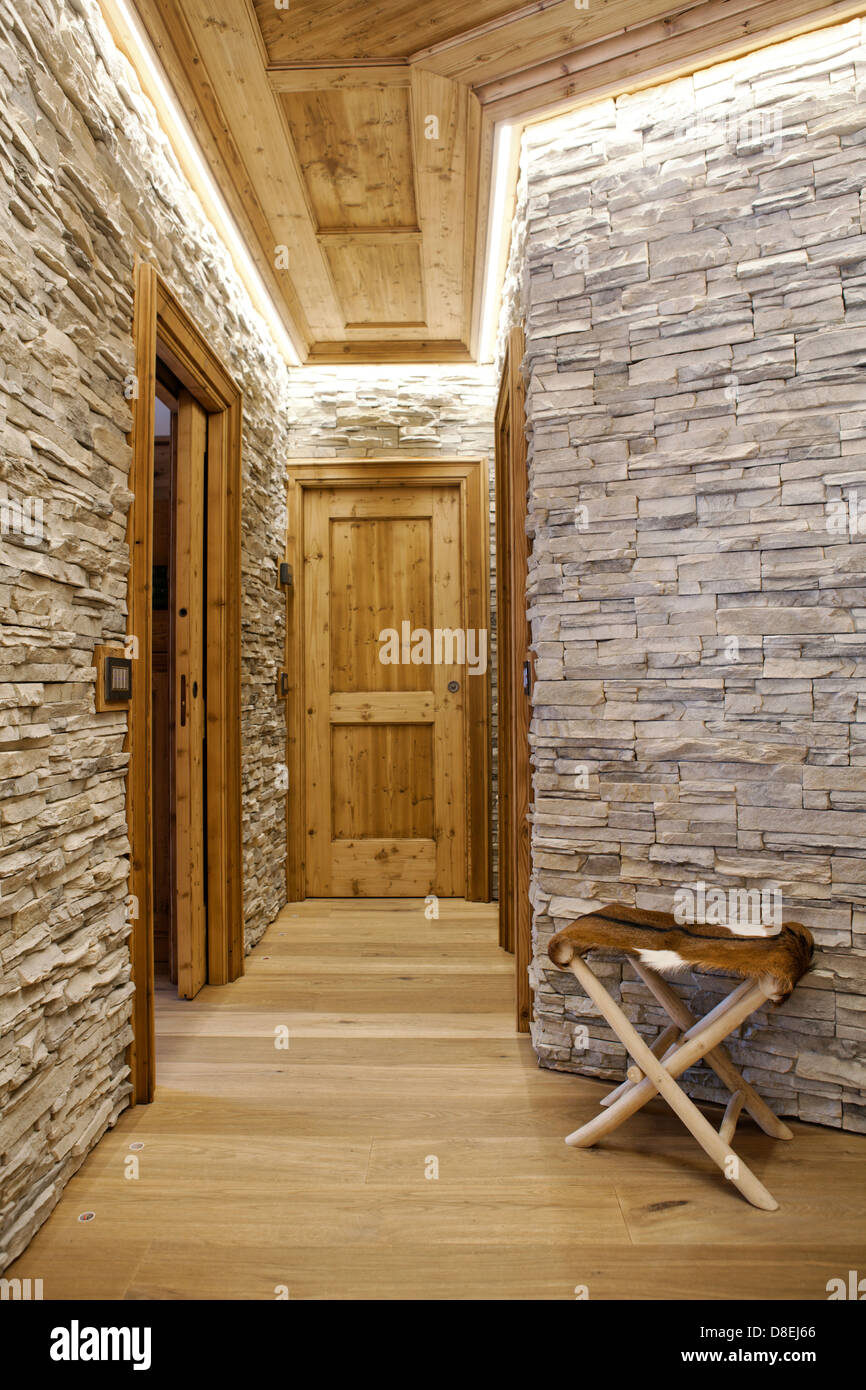 I muri in pietra naturale e pavimenti in legno e porte in questo appartamento alpino Foto Stock