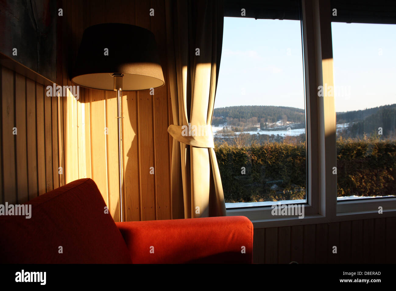 La luce solare che colpisce il soggiorno a parete con un vasto paesaggio al di fuori. Foto Stock