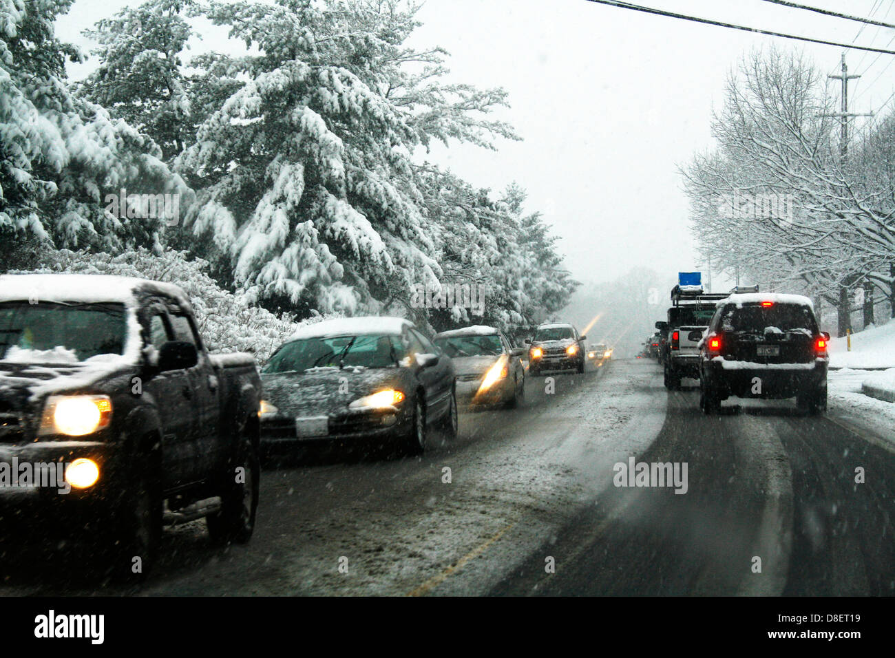 Tempesta di neve, vetture su strada mentre la neve cade. Foto Stock