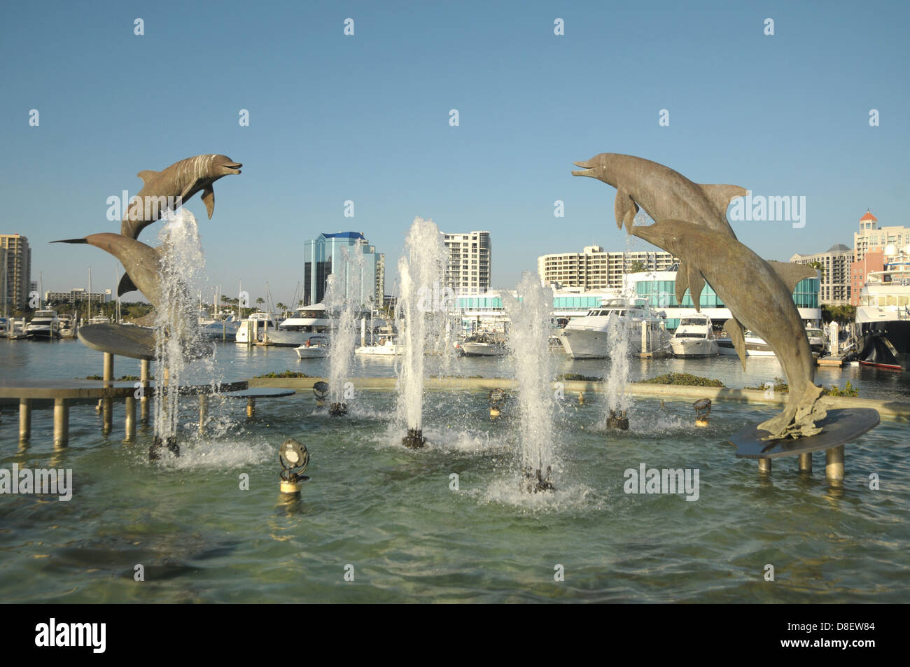 Dolphin statue si manifestano in aria a una fontana di acqua a Sarasota, FL dal lungomare. Foto Stock