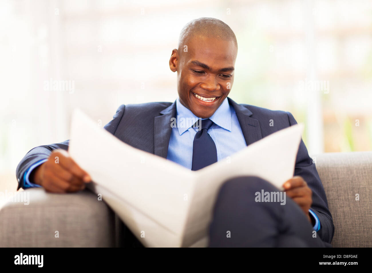 Bello africano Lavoratore aziendale leggendo il giornale in ufficio Foto Stock