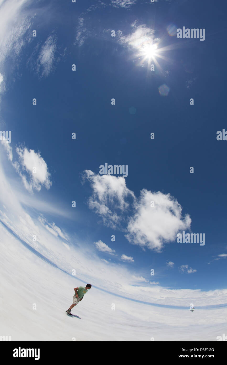 Un uomo in piedi nel tetro bianco paesaggio - Salar de Uyuni in Bolivia Foto Stock