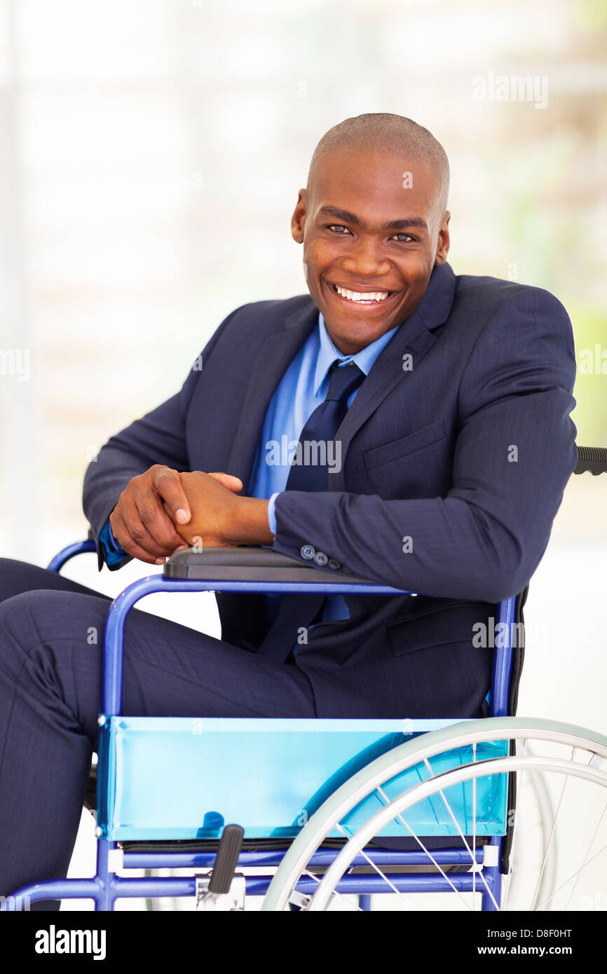 Ottimista handicappati imprenditore africano seduto su una sedia a rotelle Foto Stock