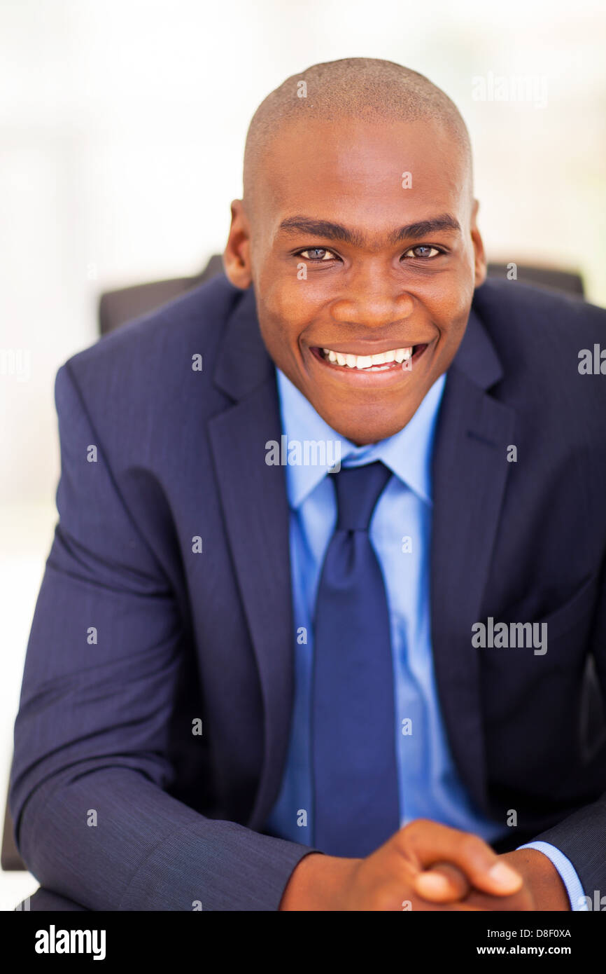 Bello imprenditore nero seduto sulla sedia da ufficio Foto Stock