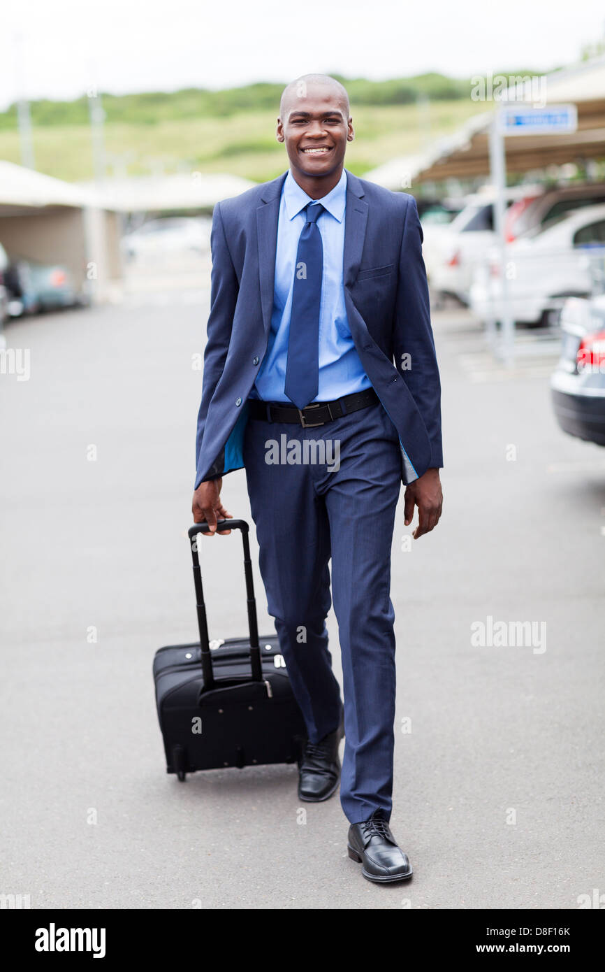 Bello imprenditore africano camminando in airport parking lot Foto Stock