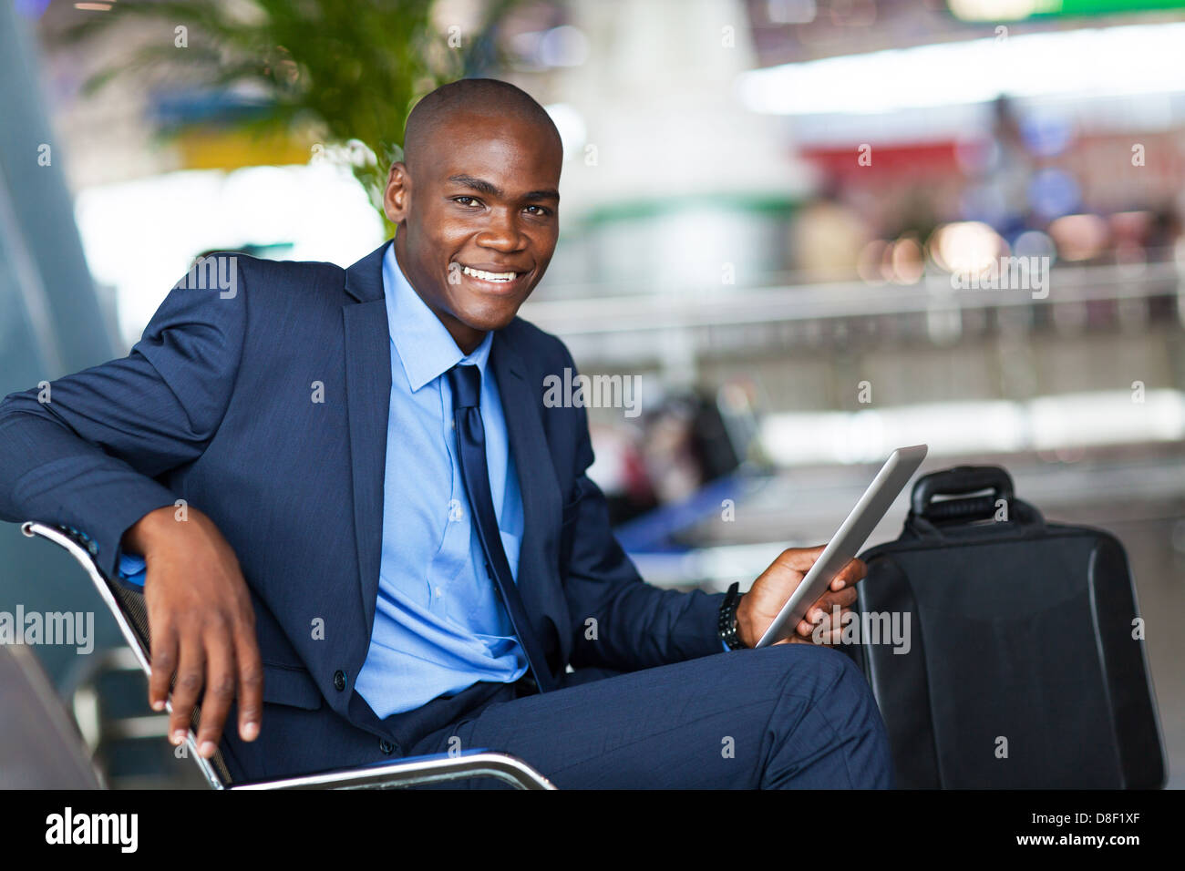 Bello imprenditore africana utilizzando computer tablet in aeroporto Foto Stock