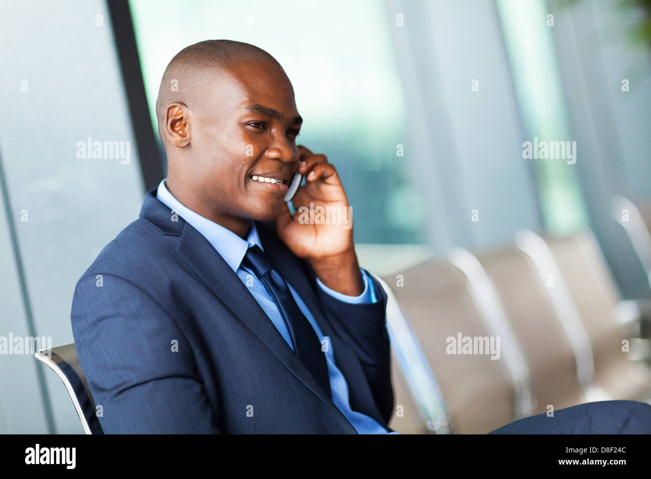 African American businessman parlando al cellulare all'aeroporto Foto Stock