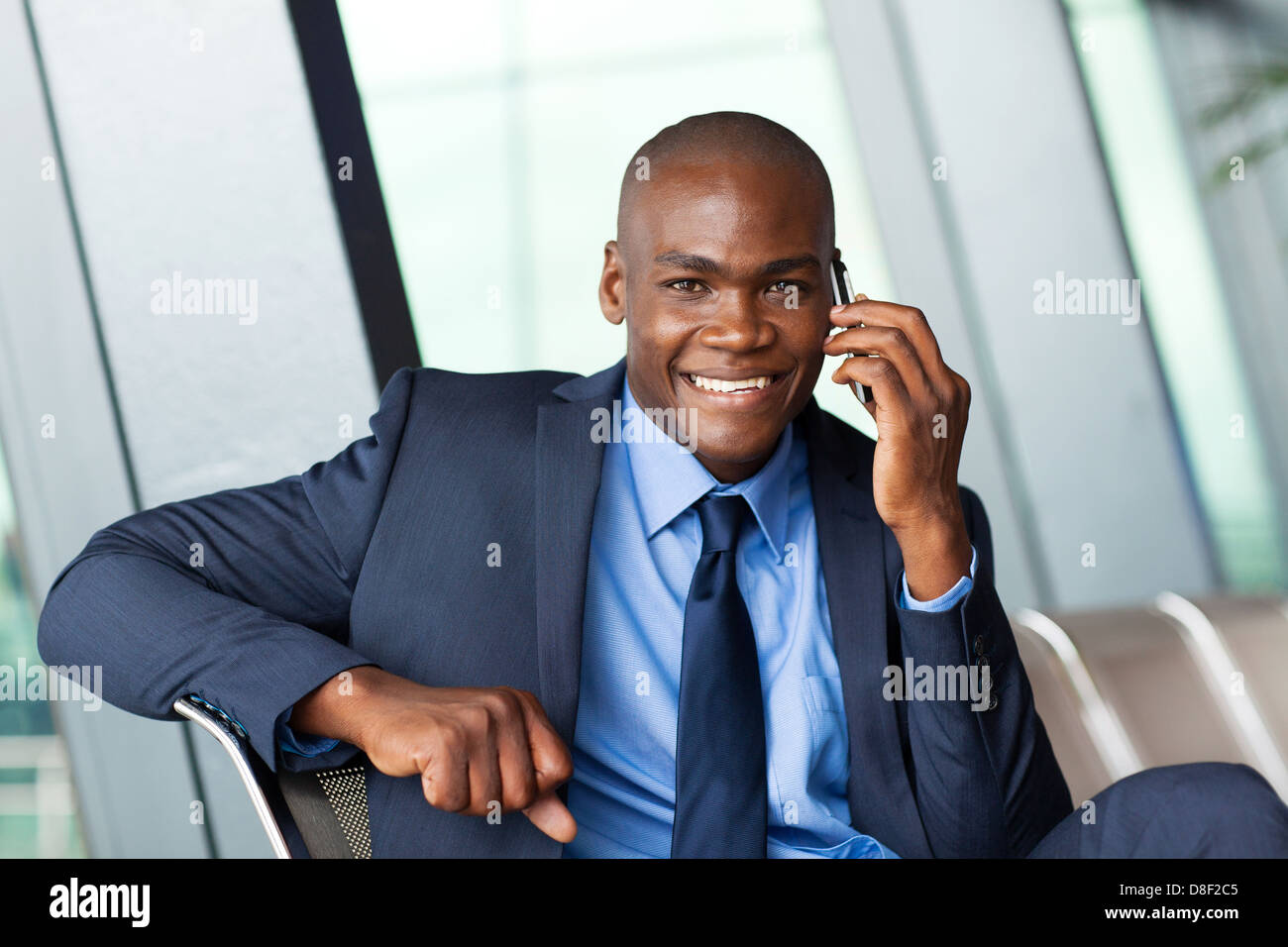 African business traveler parlando al cellulare in aeroporto Foto Stock