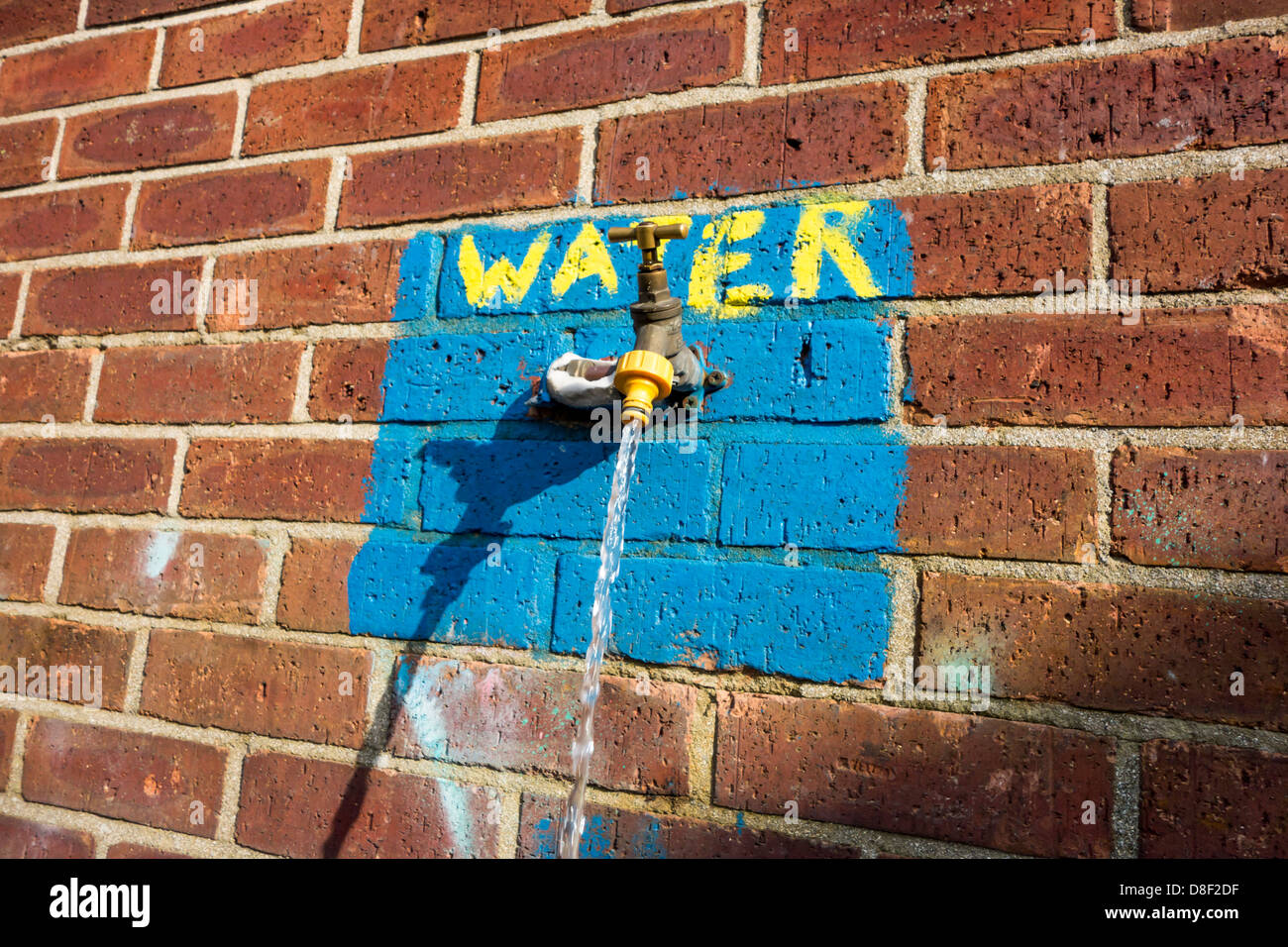 Esecuzione di acqua da un rubinetto esterno che era stato lasciato a. Foto Stock