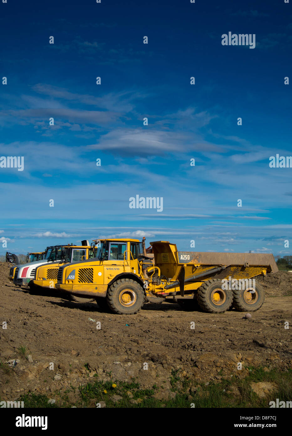 Fila di dumper in cantiere pronti a rimuovere il terreno scavato da un cantiere. Foto Stock