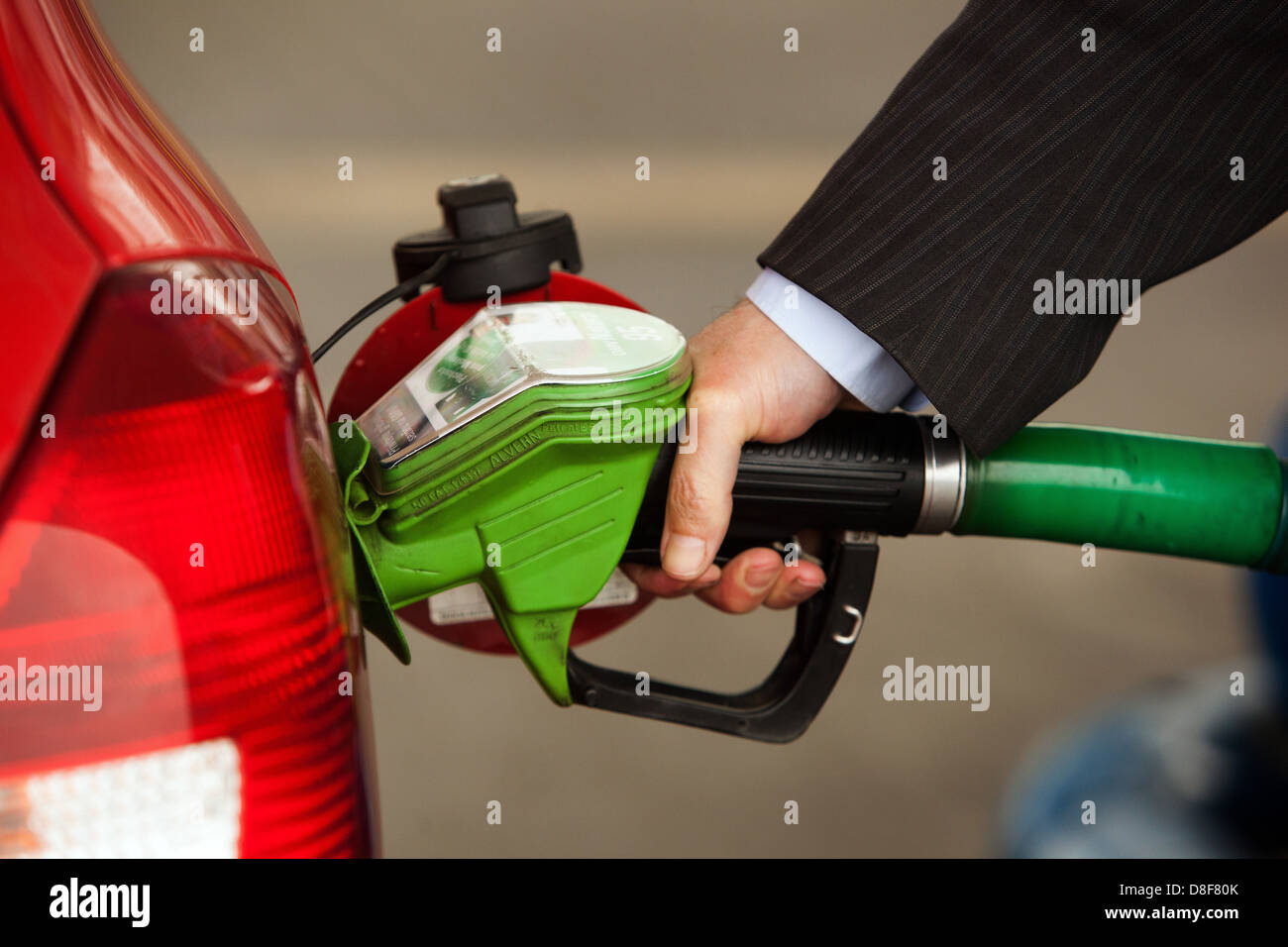 Rifornimento della vettura classica al distributore di benzina, uomo pompando a mano la pistola di benzina e riempie la benzina in una macchina Foto Stock