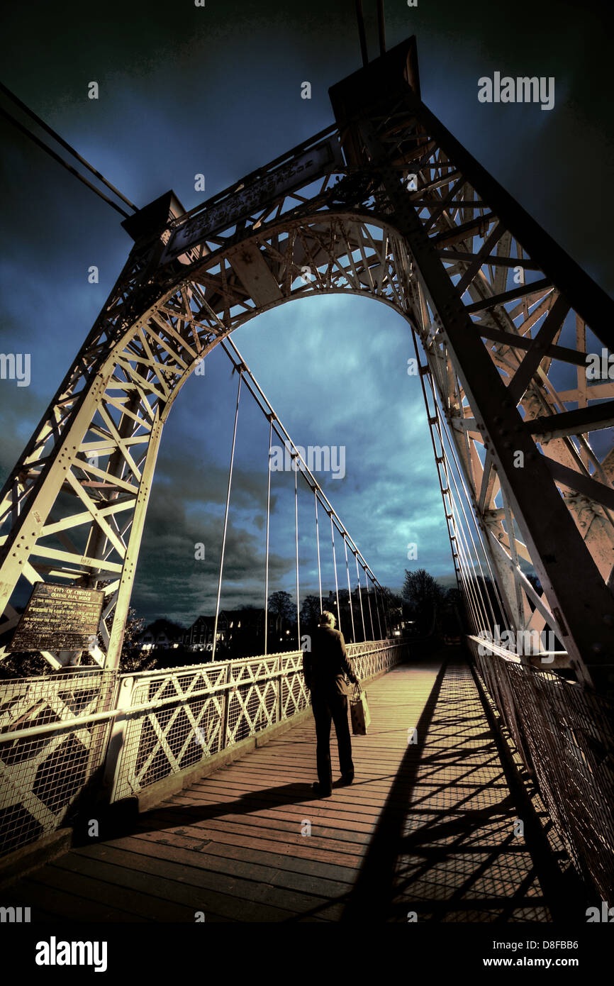 Uomo di attraversare il fiume Dee bridge a Chester con la sua valigetta , il suo modo a casa la sera Foto Stock