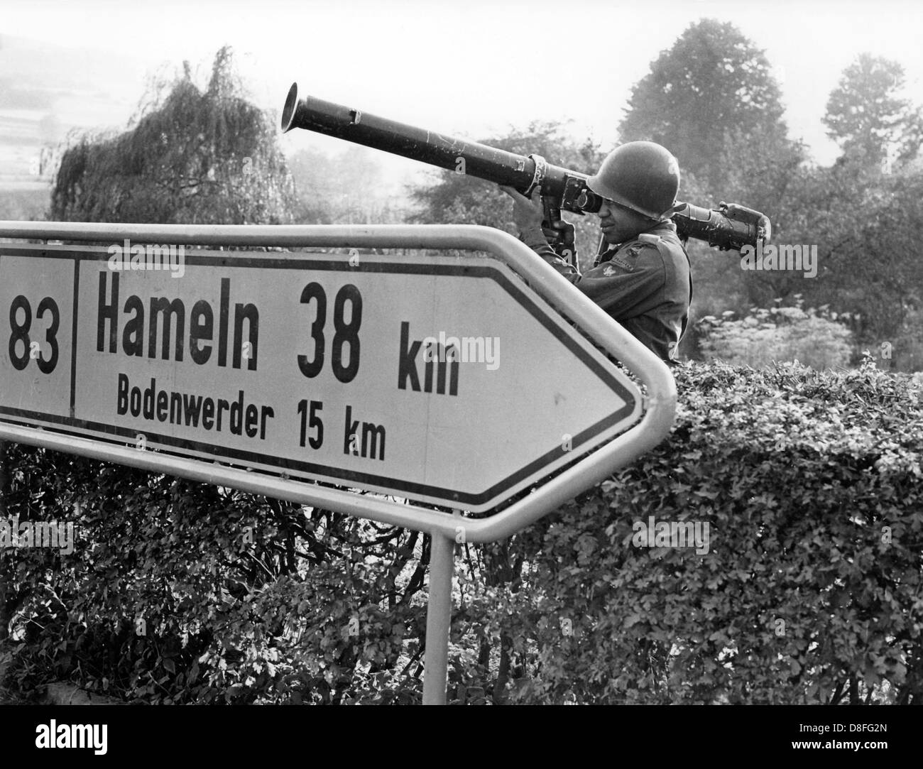 Un soldato americano, armati con un bazooka, sorge dietro un cartello stradale nella parte meridionale della Bassa Sassonia durante una manovra sul decimo di ottobre del 1962. Foto Stock