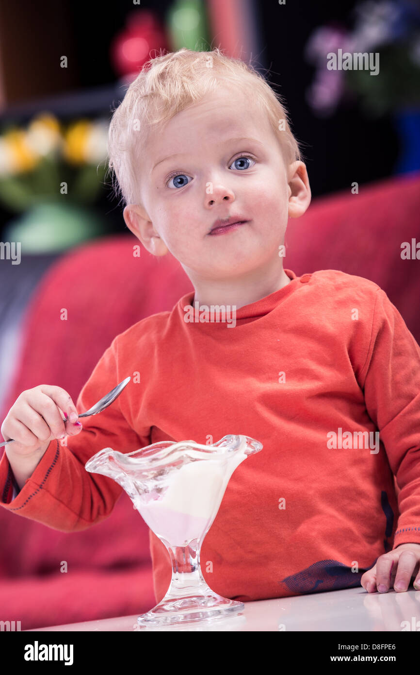Un ragazzino a mangiare il gelato a casa Foto Stock